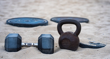 Kettlebell and weights background. Bodybuilding with heavy weights. Park workout with dumbbells. Sports scene with weights. Kettlebell, dumbbells and barbell background. Weights training outdoor.の写真素材