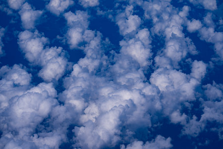Light fluffy clouds floating. Blue sky with white cloud. Background of sky with clouds. Stunning sky with white clouds. Soft cloud drifting. Peaceful sky with sunlight glow.の写真素材