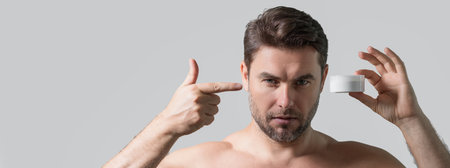 Cosmetic products. Beauty man presentation cosmetic bottle. Banner for header, copy space. Man advertising cosmetic. Male model promoting skin care product. Beauty shop.の写真素材