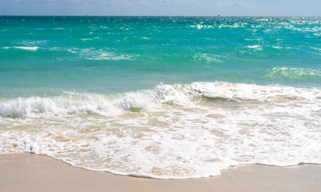 Beach background. Blue beach waves. Sandy beach shore. Beach ocean view.