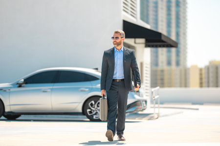 Successful businessman walk with with briefcase outdoors. Business man hold briefcase outside. Mature businessman in suit. Corporate business. Rich business man in suit. Outdoor business portrait.の写真素材