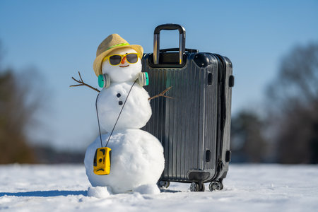 Winter holiday card with snowman and snowy background. Snowman holding gift on greeting card. Winter greeting card decorated with happy snowman. Snowman on Christmas postcard.の写真素材
