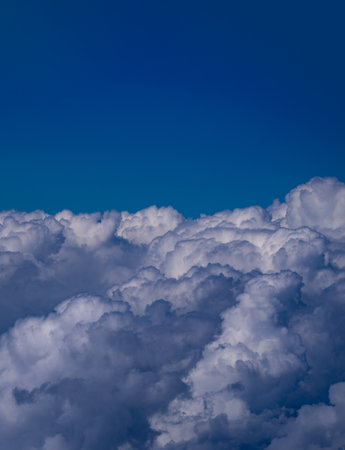 Cloudy skies. Cumulus clouds in sky. Cloud wallpaper. Sky background. Cloudy sky with sunlight. White clouds wallpaper. Blue sky and white clouds background. Idyllic fluffy clouds. Calm nature.の写真素材