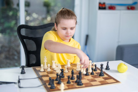 Child with chess at home. Cute kid playing thoughtful chess game. Schoolchild concentrating on chess...