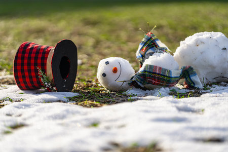 Snowman wait spring. Snowman is melting on spring day. Winter and spring, warm winter. Melted snow, winter weather, anomaly weather concept. Spring time. Winter season.の写真素材