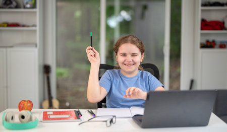 Kid learn at home with a laptop. Kid studying on a cozy desk. Study child. School child in living...