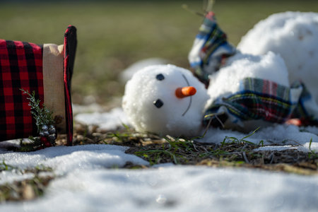 Funny Snowman fading away as warm spring weather arrives. Warm winter weather. End of winter, hello spring. Winter snowman disappearing in early spring. Winter and spring seasons change.の写真素材