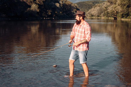 Fisherman using rod flyfishing in mountain river. A fly fisherman fishing for wild trout on the...