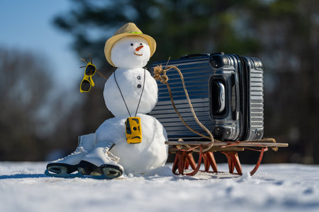 Winter travel concept. Snowman with suitcase ready for winter vacation. Snow man traveler holding travel bag. Funny snowman on travel adventure. Snowman traveler with backpack. Travel with snowman in winter.の写真素材