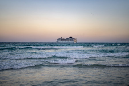 Cruise ship on the ocean. Luxury liner at sea. Miami Beach with cruise ship. Turquoise water and cruise liner. Tourist cruise ship near the coast. Ocean waves and vessel boat. Summer vacation. Boat trip.の写真素材