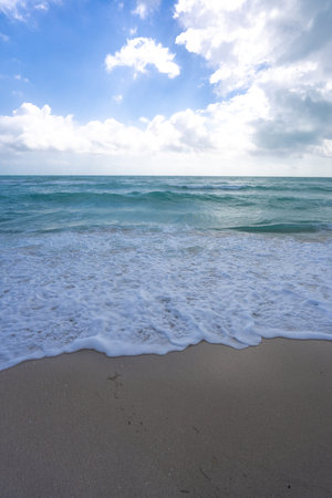 Ocean waves and sand, summer coastline background. Stormy sea waves. Summer sea beach wave. Foamy ocean waves. Summer ocean breeze. Dreamy summer beach background. Ocean splash waves.の写真素材