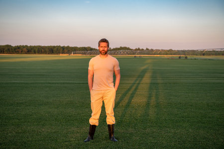 A farmer is walking through the farm. The man is watering the plants in the farm field. Irrigation...