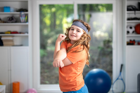 Child practicing fitness in home. Cute little boy doing morning fitness . Young sporty kid exercising in room. Child fitness. Kids sport concept. Kid enjoying fitness training indoors.の写真素材