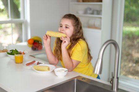 Kids eating healthy breakfast in the morning. Happy kids eating corn at the kitchen.の写真素材