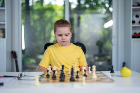 Kid think chess. Thoughtful child playing chess at desk. Clever boy learning logic with chess. Students practicing chess in classroom. Cozy home scene with kid and chessboard.の写真素材