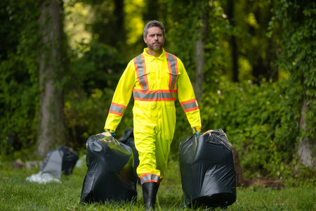 Volunteer man collecting garbage, picking up waste at nature. Land pollution, environmental problem. Landfill a pile of plastic garbage. Pollution of nature. Ecology concept. Pollution environmental.の写真素材