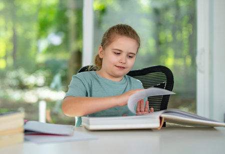 Child relaxing while reading a book at home. Happy kid exploring literature in home interior. Little reader enjoying bedtime story at home. Kid reading and learning in playroom.の写真素材