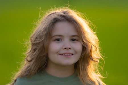 Close-up portrait of kid in summer. Kids face. Summer portrait of happy child. Child face in park. Portrait of cheerful kid outdoors. Fun face of child. Child enjoying summer. Summer vibes.の写真素材