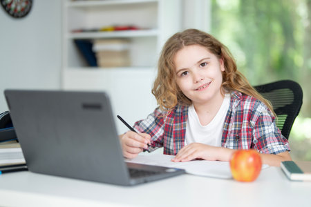Child gaining knowledge in home school. Kid studying online lesson at home. Young student focused on...