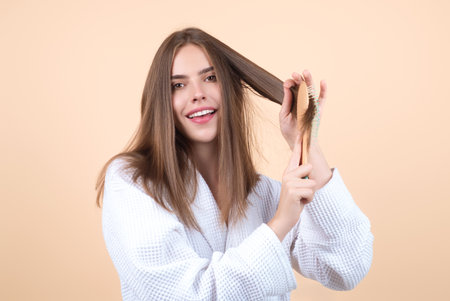 Beautiful woman combing her hair in studio.