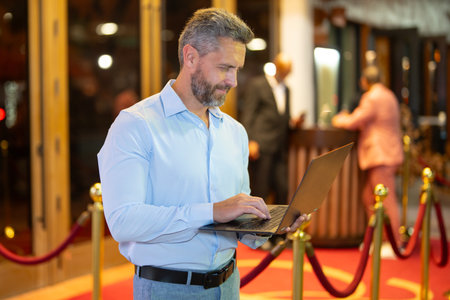 Businessman using a laptop on street at night. Businessman planning work on laptop outdoors....