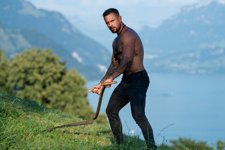 Man in a village farm. Environmental worker in grassy field. Hardworking farmer in a rural landscape. Country life in summer. Farmer enjoying nature in countryside. Traditional farming.の写真素材