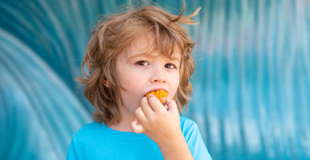 Child eating cake with happy face. Kid bite of sweet cake. Cute child eat sweet cookie. Child picking sweets. Delicious sweets for children. Dessert time. Cute child holding big piece of cake.の写真素材
