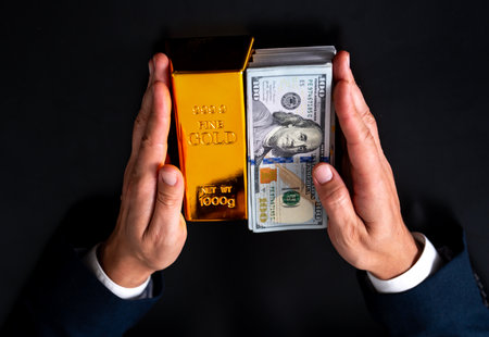 Gold bar in hand. Showing gold and financial success with gold bar concept. Rich investor and...