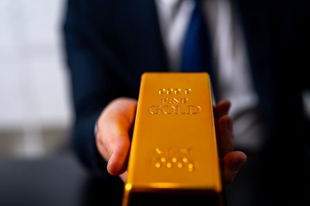 Gold bar in hand for investment. Gold and financial investment with gold bar concept. Rich investor and investment deal. Golden bar as a symbol of success investment. Gold for investment and banking purposes.の写真素材