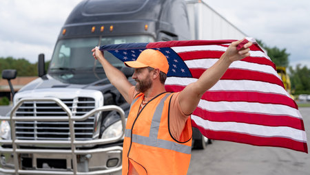 Truck drivers is a dream job in America. Truck driver hold American flag. A trucking career in the USA. Truck driver country travel. Truck driver best profession in America. Desirable jobs in America.の写真素材