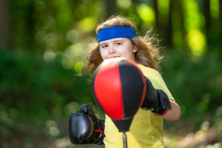 Child doing sport fitness outdoor. Sporty boy exercising sport in summer park. Kid practicing sport outdoor. Child stretching body for health. Child enjoying sport fitness. Child workout fitness.の写真素材