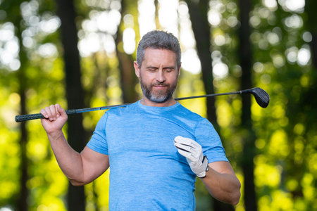 Golf man holds golf ball during outdoor training. A golfer prepares to play in golf club on a green...