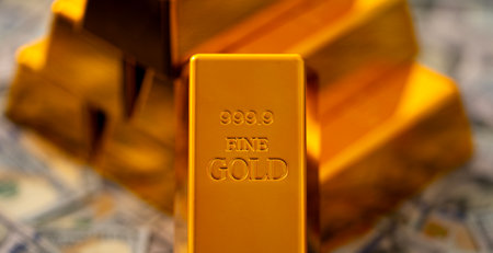 Gold bars and money. Golden bars stacked with US dollars in background. Gold bars for secure capital growth. Dollars money and gold concept. Financial success and saving Gold.の写真素材