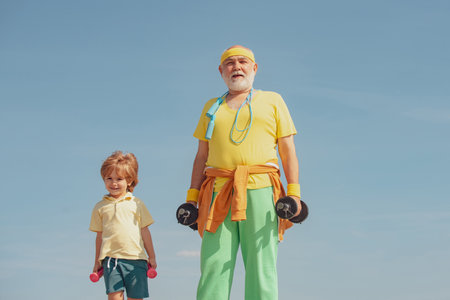 Active healthy life for family. Sports for kids. Senior man and child exercising on blue sky.の写真素材