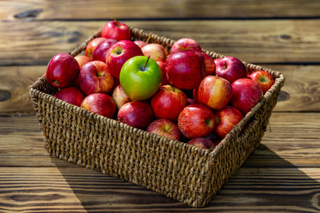 Fresh red apples in basket on wooden table. Juicy organic apples harvested from farm. Autumn season fruit. Ripe organic apple. Harvest with fresh red apples. Basket full of fresh apples.の写真素材