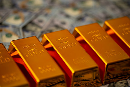 Gold and money. Gold secure investment. Golden bullion bars stacked with US dollars for financial growth. Cash and pure gold for savings and capital reserve. Gold bars for banking.の写真素材