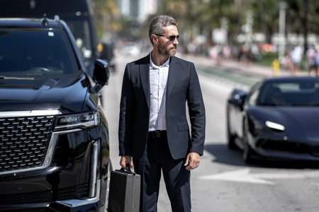 Rich businessman near luxury car. Rich businessman outdoor. Elegant rich businessman. Rich...