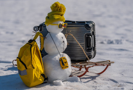 Winter holiday card with snowman and snowy background. Snowman holding gift on greeting card. Winter greeting card decorated with happy snowman. Snowman on Christmas postcard.の写真素材