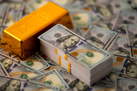 Gold bars and money symbol of investment. Shiny golden bars stacked with US dollars in background. Gold bars for secure capital growth. Money and gold concept. Financial success and saving Gold.の写真素材