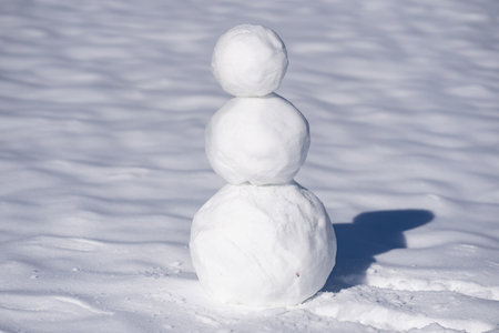 Snow man on outdoor winter field. Winter snowman for New Year design. Snowman with scarf and gloves. Snow man with copy space for banner.の写真素材