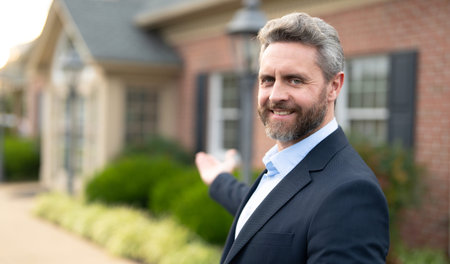 Real estate agent front of a new house. Realtor estate agent shows residential building in suburbs. Realtor broker reviews mortgage. Realtor celebrates home ownership. Realtor business man.