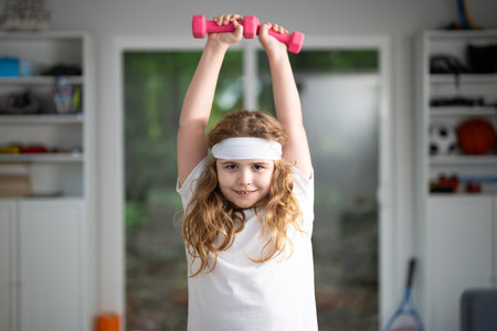 Kids doing sport fitness at home. Little boy exercising at home. Kid practicing fitness at home. Child stretching body for healthy lifestyle. Kid enjoying sport fitness at home. Kid workout in kids room.の写真素材