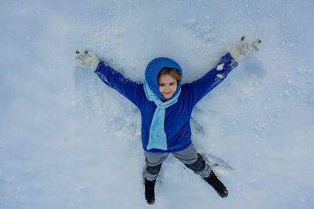Winter with kid. Child enjoying winter vacation. Kids playing in frosty snowfield. Child laughing in...