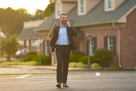 Realtor hands keys to a happy homeowner. Real estate agent inspects an apartment interior. Realtor explains property financing. A real estate broker stands confidently outside a residential building.の写真素材