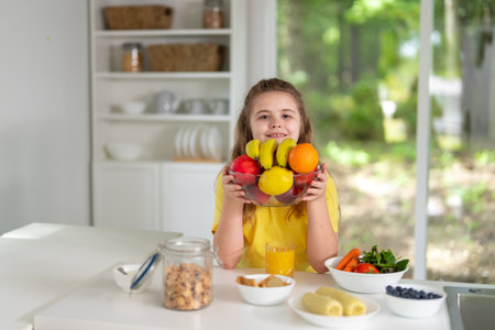 Child eating fruits at home kitchen. Kid at the kitchen dining table.の写真素材