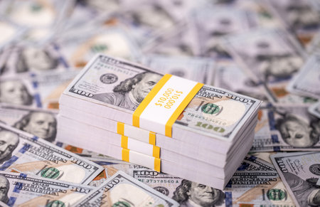 Stack of dollars and cash with a money background. US currency and banknotes. Pile of 100 USD bills. American hundred-dollar notes. Pattern of dollars. Cash and credit theme. Deposit money.の写真素材