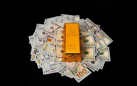 Gold and money. Gold secure investment. Golden bullion bars stacked with US dollars for financial...