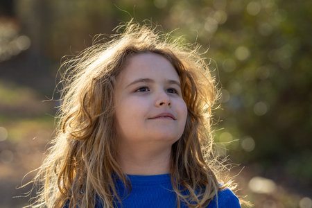 Carefree kid in a meadow. Child imagining. Outdoor portrait of a dreamer kid. Freedom and innocence...