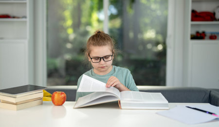Kid reading a book in the living room. Child at home reading a book. Child 10 years old read book...