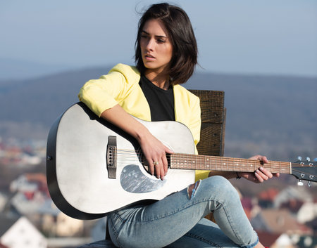 Beauty woman plays guitar music. Creative musician play an acoustic guitar outdoors. Music passion....